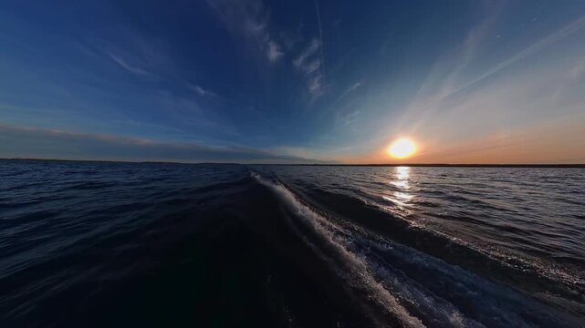 Boat wake foaming at water from outboard motor rear view. Waves from the outboard engine at high speed boat during stunning sun set. Wave from the boat moving. White foam from waves.