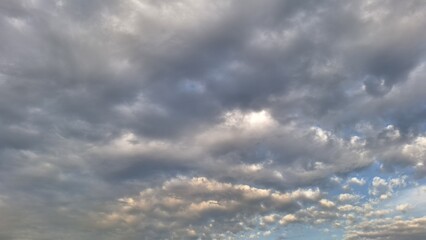 Obraz premium Overcast sky with grey storm clouds and sunset light