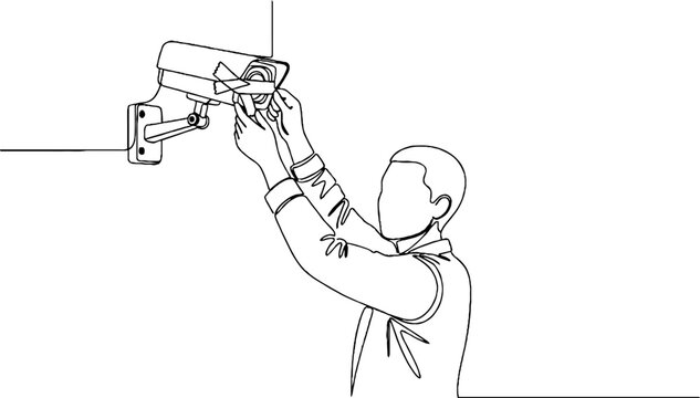 Technician installing security camera on wall.