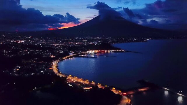 Drone aerial view of Legazpi City Boulevard at sunrise with majestic Mayon Volcano backdrop and dramatic clouds, Albay
