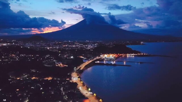 Drone aerial view of Legazpi City Boulevard at sunrise with majestic Mayon Volcano backdrop and dramatic clouds, Albay