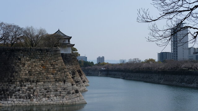 Ancient Japanese Castle Moat and Stone Walls Against Modern Osaka Skyline
