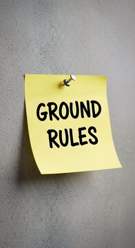 Yellow sign with ground rules text on concrete wall.