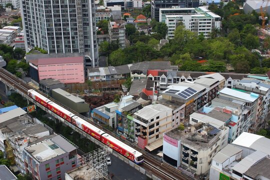 BANGKOK, THAILAND - JUNE 21, 2026: Modern condominiums with a swimming pool and surrounding cityscape in Phra Khanong district.