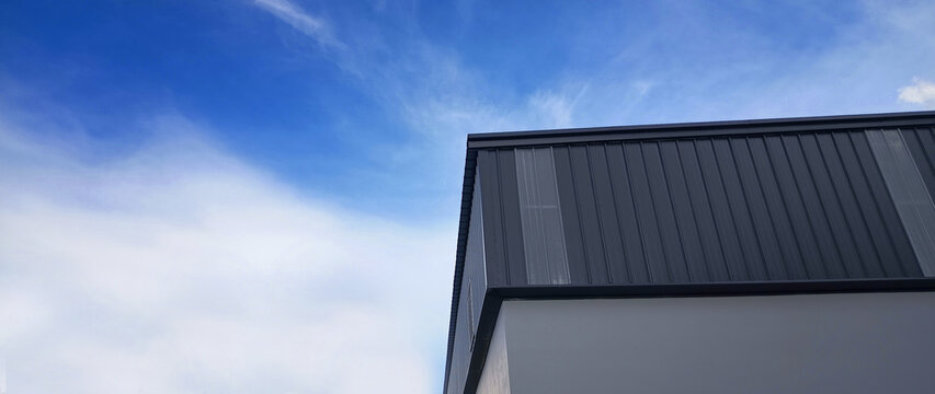 Metal sheet roof curve on blue sky. Modern construction, Metal ribbed arch span roof covering, Large building roof. not ai