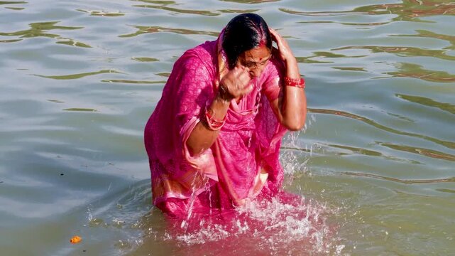 Woman Immersing in Holy River During Hindu Religious Purification Ceremony