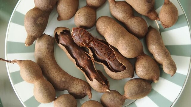 Discovering tamarind fruit on a plate in home kitchen