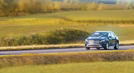 Fototapeta premium Automobile traveling on a peaceful rural road