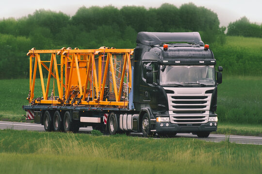 Transport vehicle carrying heavy equipment on countryside road