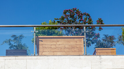 Obraz premium Balcony railing and wooden planters against blue sky