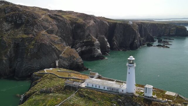 Aerial view of South Stack Lighthouse on a rocky island with steep cliffs and the Irish Sea in Holyhead, Wales, United Kingdom.
