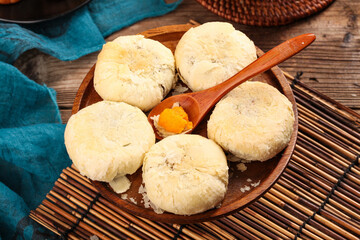 Fototapeta premium Traditional Handmade Mooncakes with Egg Yolk on Wooden Plate for Mid-Autumn Festival