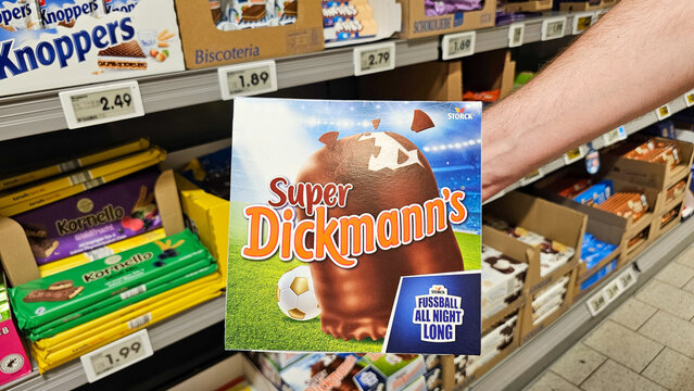 Hand picking super dickmann's football candy in supermarket