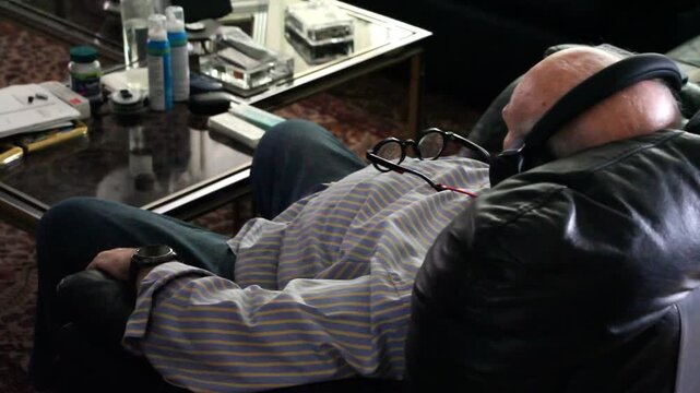 Anciano en sill&oacute;n viendo tele tv casa viejo sof&aacute; cascos, gafas de ver siesta time sal&oacute;n tranquilidad, televisi&oacute;n se&ntilde;or mayor descansando reposabrazos tirado y repanchingado cansado