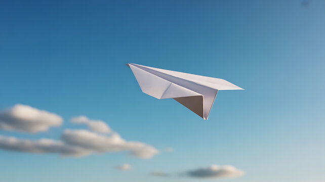 A white paper airplane flying against a clear blue sky with scattered clouds