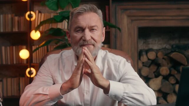 Caucasian senior old business man taking off glasses looking at camera positive posing at table at home office elderly aged businessman calm mature male professional lawyer folded hands folding arms