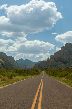 Desert highway leading into rocky mountains