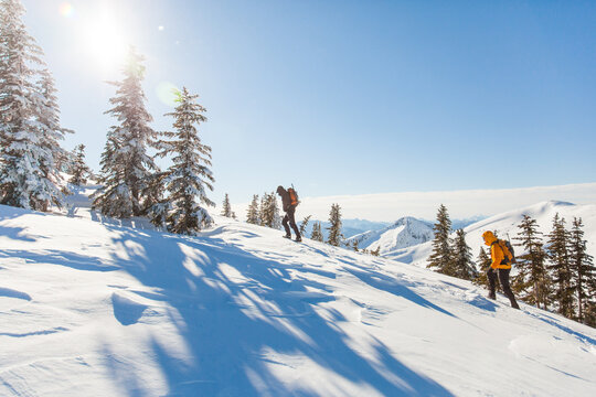 Two mountaineers hike up a snowy mountain slope