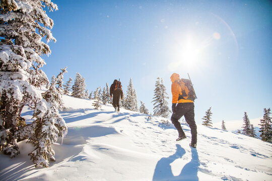 Two mountaineers hike up a snowy mountain slope