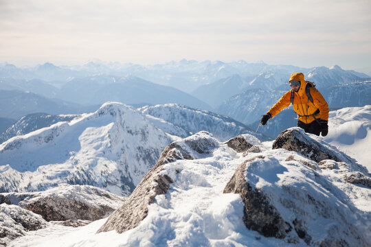 Mountaineer traverses a snowy ridge in winter
