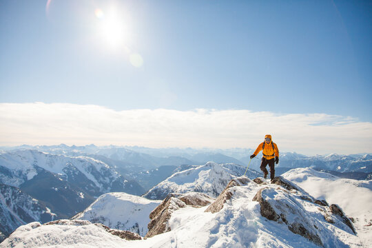 Male mountaineer hikes along a snowy mountain ridge