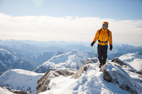 Man hikes along a snowy mountain ridge line