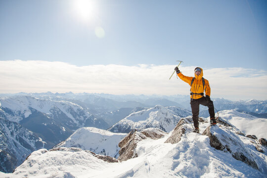 Triumphant mountaineer at a snowy mountain summit
