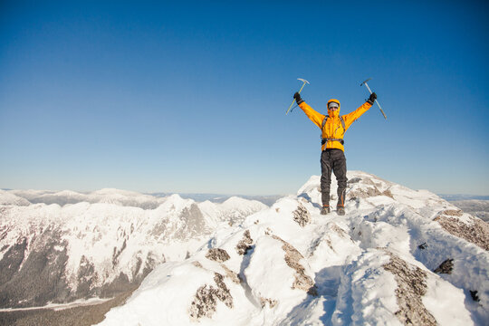 Victorious hiker on a snowy mountain summit