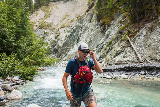 Man wades through a fast moving mountain river
