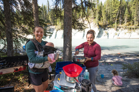 Friends and family cooking at a riverside campsite