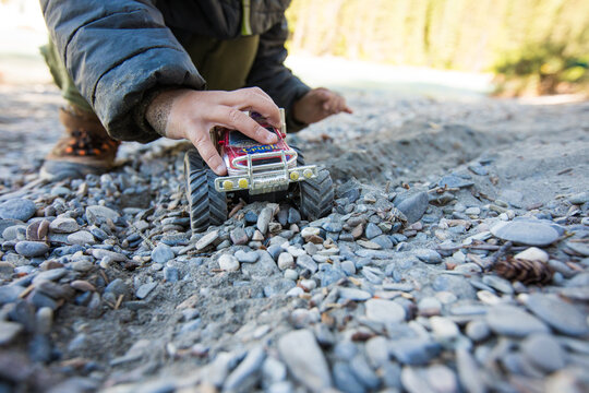 A young child plays with a red monster truck toy