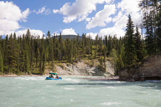 Group rafting on a turquoise river through a forest