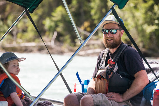Happy bearded man and child on a river boat trip
