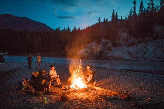 Group of friends relaxing by a campfire at night