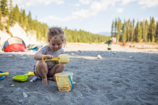 Young girl plays with sand toys at a campsite