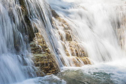 White water cascades over golden rock steps