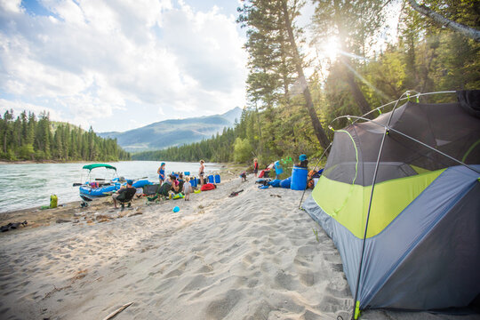 Family and friends camping on a sandy river beach