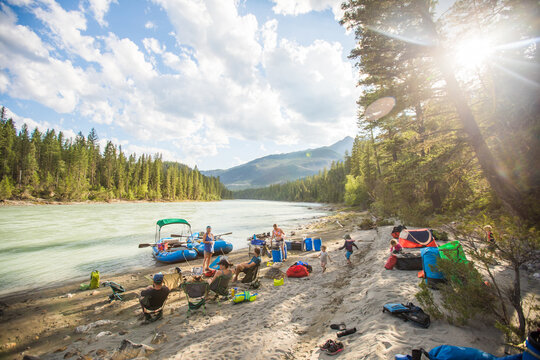 Family and friends camping on a sunny river beach