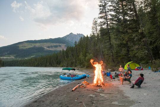 Friends enjoy a bonfire on a river camping trip