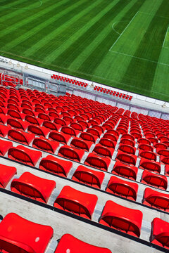 High angle view of empty red stadium seats overlooking a green sports
