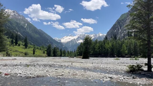 beautiful view of kumrat valley. white  cloud on blue sky and mountain coverd with snow and trees