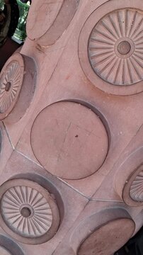 ​Intricate Dharma Chakra Stone Carvings on Red Sandstone Structure