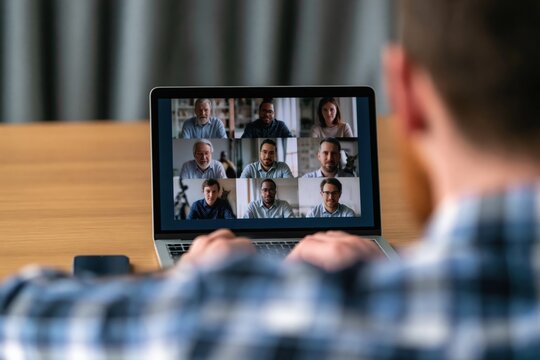 Remote work professional on laptop in virtual video conference meeting with team