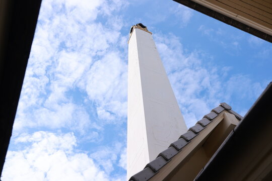 Thai temple crematorium chimney towering up into the bright blue sky.