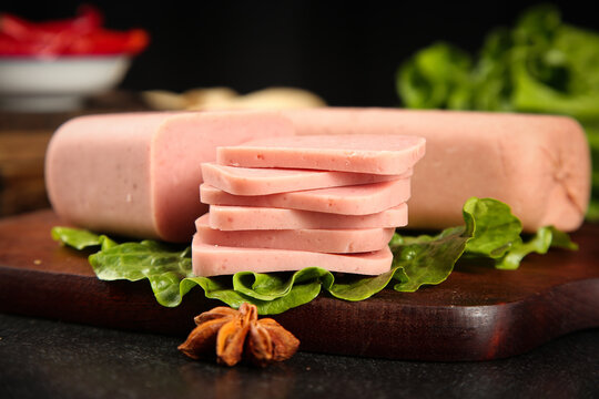 Sliced Pork Meat Product with Fresh Lettuce on Wooden Board