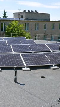 The Concept of Green Energy in an Urban Environment. Solar panels on the roofs of old apartment buildings. A rooftop solar power plant - Vetical video