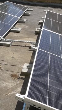 The Concept of Green Energy in an Urban Environment. Solar panels on the roofs of old apartment buildings. A rooftop solar power plant - Vetical video