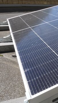The Concept of Green Energy in an Urban Environment. Solar panels on the roofs of old apartment buildings. A rooftop solar power plant - Vetical video