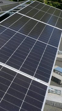 The Concept of Green Energy in an Urban Environment. Solar panels on the roofs of old apartment buildings. A rooftop solar power plant - Vetical video