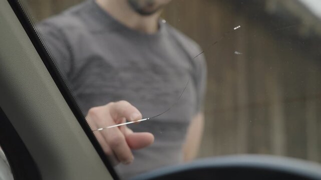 Male person check the fractured windscreen on the car view from inside 4K